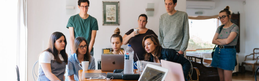 Young law graduates searching for legal jobs on a laptop using Legal Career Connect Tampa Bay.